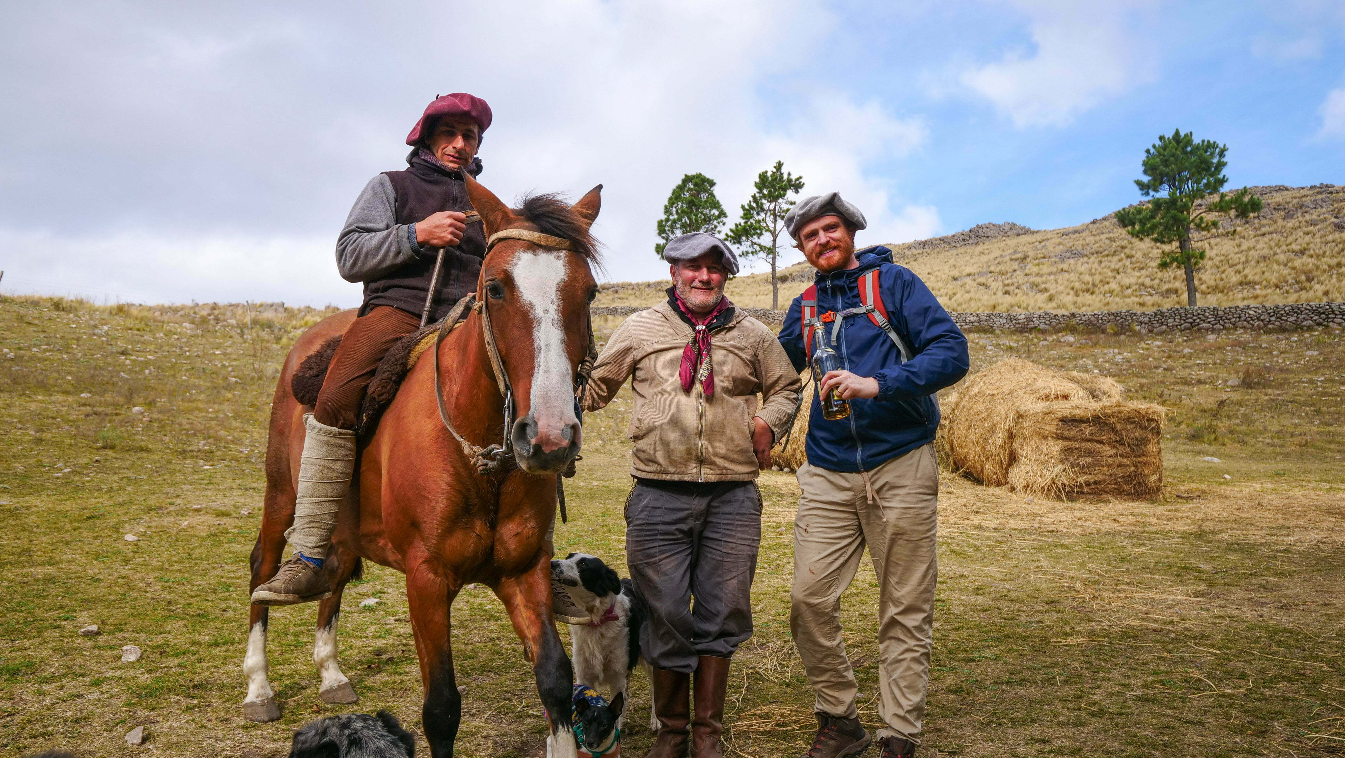 Nomadic Samuel enjoying drinks with gauchos on horseback in Argentina
