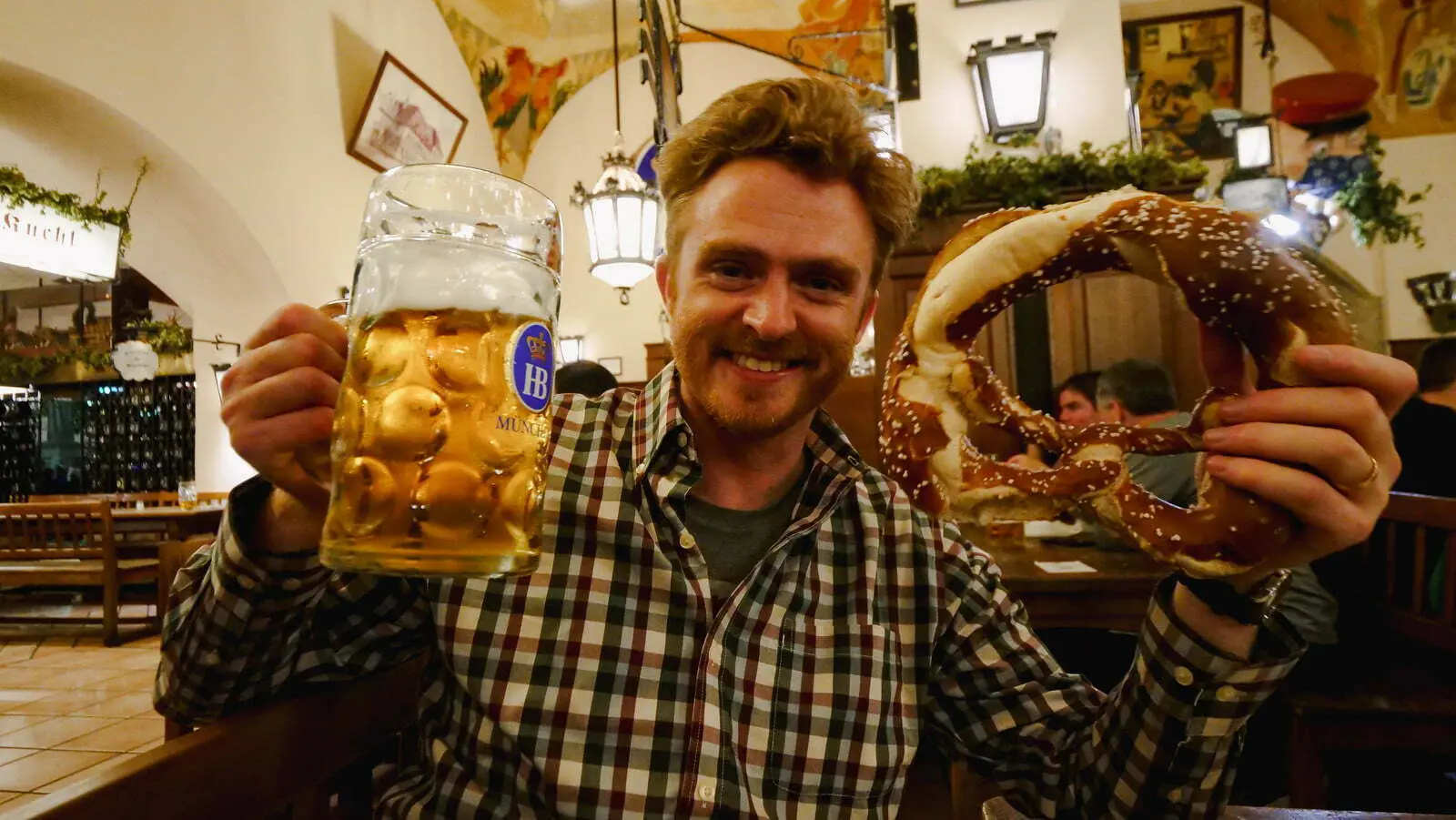 Nomadic Samuel enjoying a giant beer and pretzel in Munich, Germany