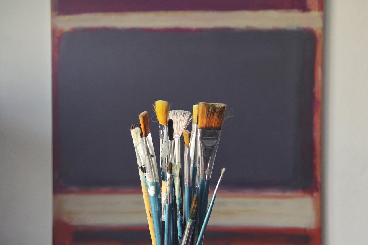 Brushes with a canvas behind it 