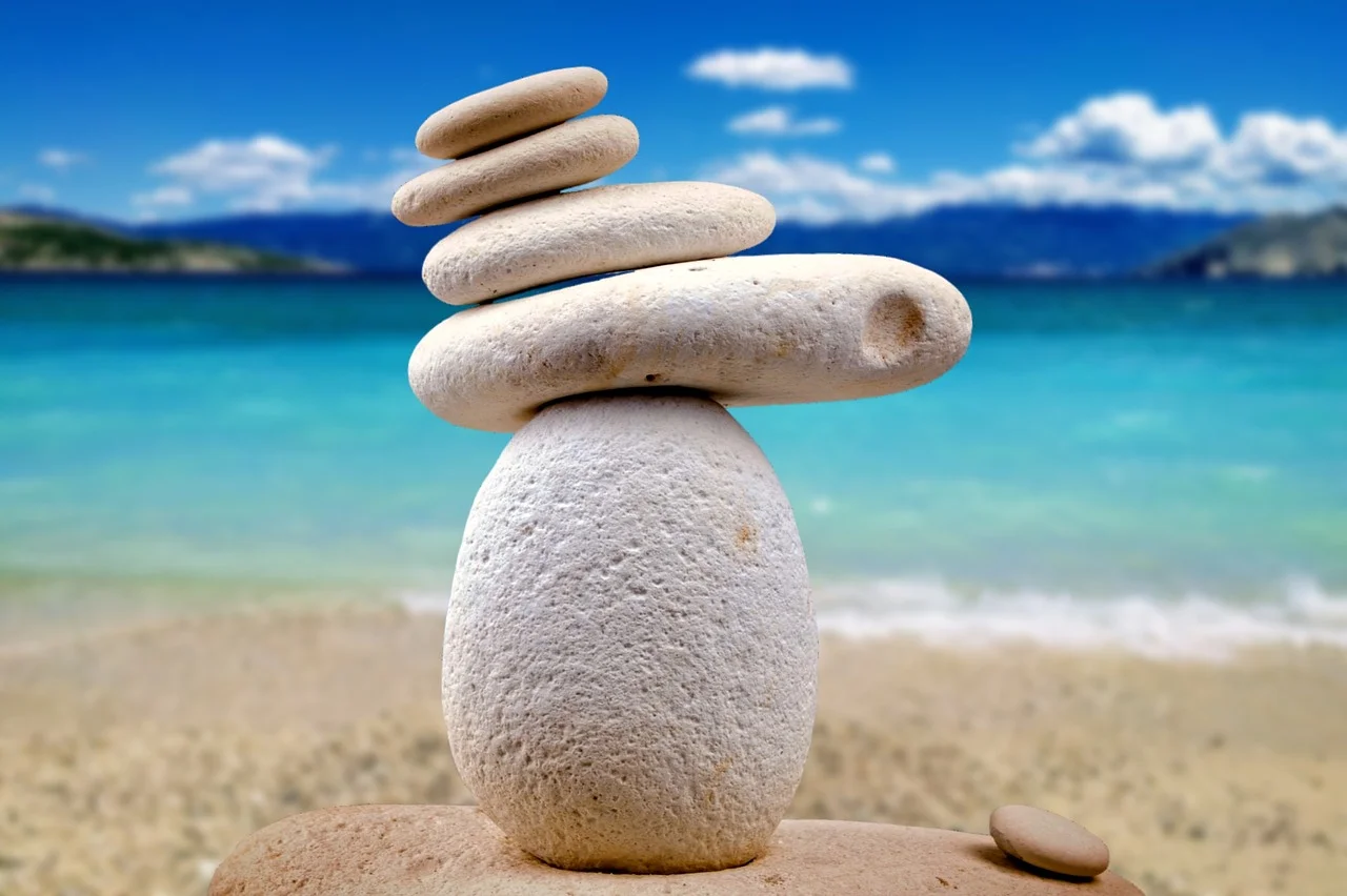 Stacking white rocks on top of each other overlooking the beach