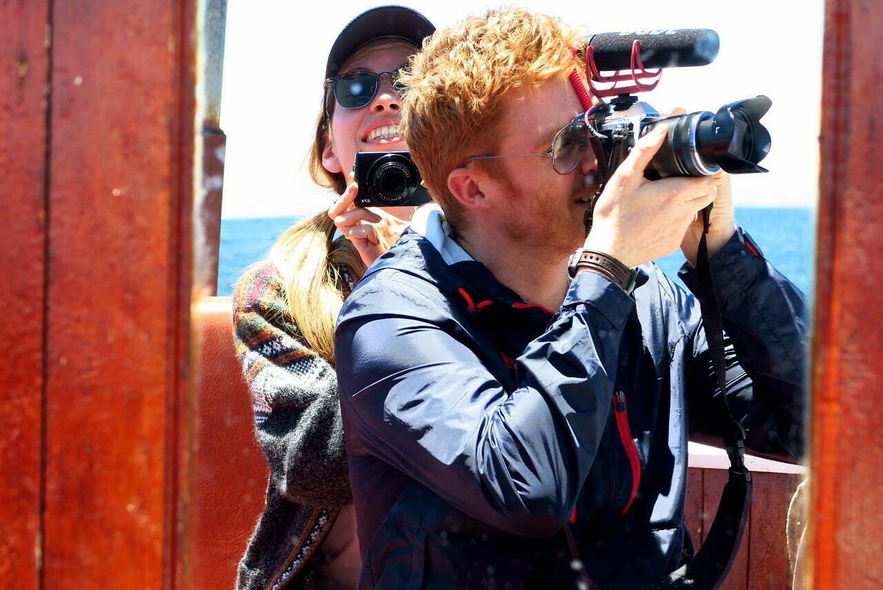 Nomadic Samuel filming a travel video while visiting Lake Titicaca in Peru