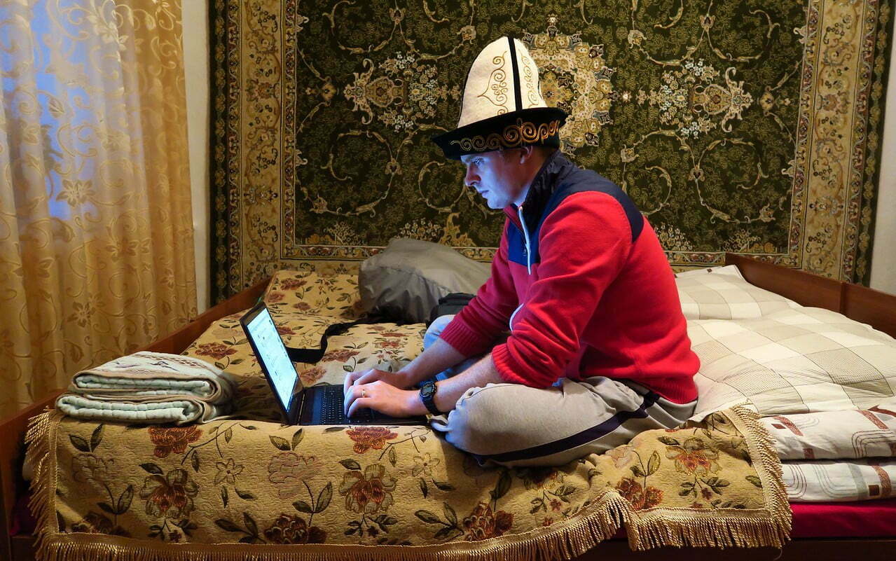 Nomadic Samuel being a digital nomad in Kyrgyzstan wearing a traditional hat