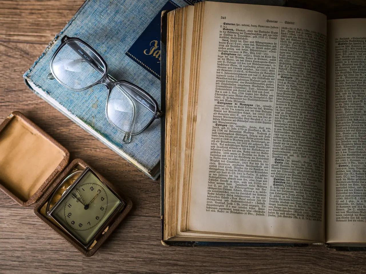 Books glasses and watch representing reading as a skill to improve your knowledge as an investor
